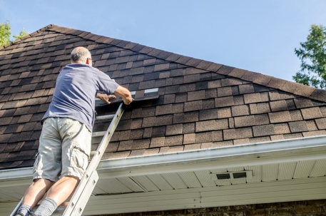 Mature man repairing asphalt shingle roof